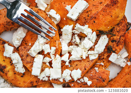 Fork over bright orange grilled butternut squash and white feta cheese Fork over bright orange grilled butternut squash and white feta cheese 123881020