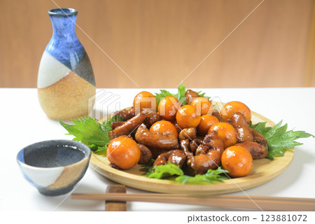 Chicken offal stew served on a wooden plate and sake 123881072