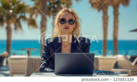 A young beautiful blonde woman with poker-face in a black business suit sits on cafe terrace at a resort and works on laptop computer. Work And Travel This is AI-generated item A young beautiful blonde woman with poker-face in a black business suit sits on cafe terrace at a resort and works on laptop computer. Work And Travel This is AI-generated item 123881329