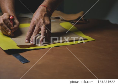 Shoemaker cutting leather with precision and craftmanship 123881622
