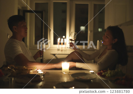 Young couple enjoying romantic candlelit dinner with wine at home Young couple enjoying romantic candlelit dinner with wine at home 123881780