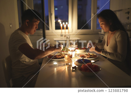 Asian couple enjoying romantic candlelit dinner at home Asian couple enjoying romantic candlelit dinner at home 123881798