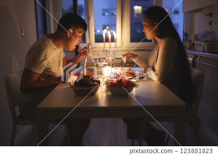 Young couple enjoying romantic candlelit dinner at home Young couple enjoying romantic candlelit dinner at home 123881823
