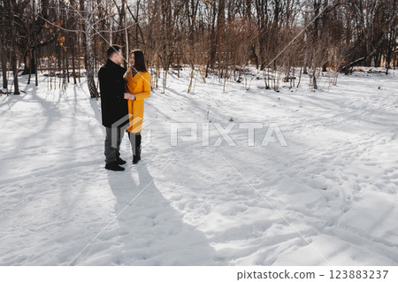 Couple enjoying a winter day in a snowy forest setting with vibrant colors 123883237