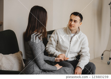 Couple engaged in a conversation in a modern indoor setting during daytime 123883239