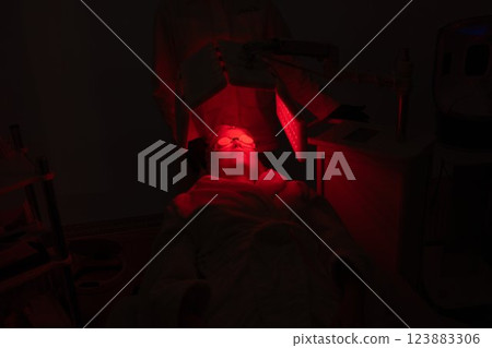 Relaxing skin treatment in a dimly lit room with red lighting 123883306