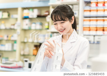 A pharmacist who uses an automatic packaging machine at a pharmacy or drug store to prepare powdered medicine, dispensing, and prescriptions 123885433