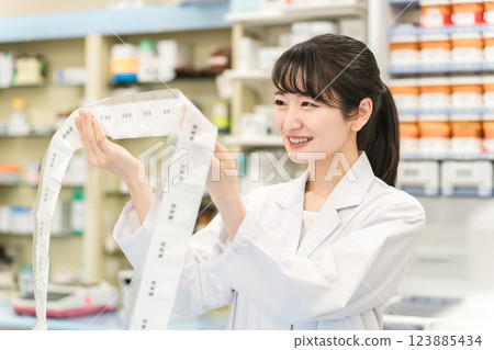 A pharmacist who uses an automatic packaging machine at a pharmacy or drug store to prepare powdered medicine, dispensing, and prescriptions A pharmacist who uses an automatic packaging machine at a pharmacy or drug store to prepare powdered medicine, dispensing, and prescriptions 123885434