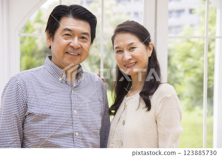 A lively middle-aged couple standing side by side A lively middle-aged couple standing side by side 123885730