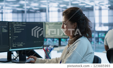 Portrait of smiling technician programming in AI data center used for machine learning training. Cheerful IT expert running code to upgrade artificial intelligence tech, camera A 123885993