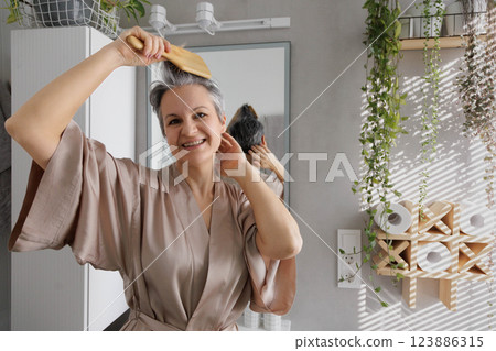 An elderly well-groomed and beautiful woman in her ages, a pensioner in silk pajamas 123886315