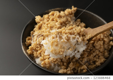 Lift up the rice topped with minced chicken using a spoon 123886468