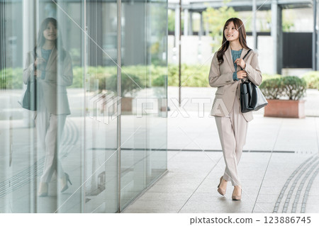 年輕的亞洲女商人在城市的辦公區散步 123886745