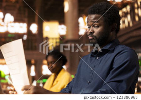 Stressed male student feeling frustrated about the academic struggles of memorizing theoretical notes for upcoming exams. Scholar being upset and worried about his grades, school burnout. Stressed male student feeling frustrated about the academic struggles of memorizing theoretical notes for upcoming exams. Scholar being upset and worried about his grades, school burnout. 123886963