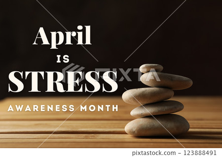 Stress month, balancing stones on wooden table on dark background, with text Stress month, balancing stones on wooden table on dark background, with text 123888491