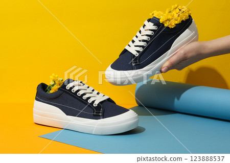 Stylish sneakers with flowers on a yellow background Stylish sneakers with flowers on a yellow background 123888537