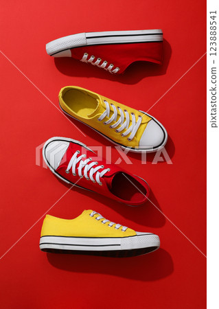 Red and yellow sneakers on a red background 123888541
