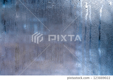 Water droplets on moist glass with a soft blur, ideal for creative projects, backgrounds, or conveying a subtle, natural mood. 123889022