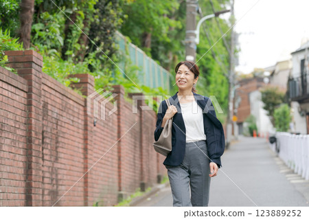 Middle-aged woman walking in a suit Middle-aged woman walking in a suit 123889252