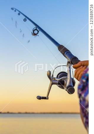 A fisherman with a fishing rod A fisherman with a fishing rod 123889716