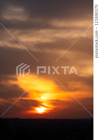 Vertical image of fiery sunset sky above urban horizon silhouette. Vertical image of fiery sunset sky above urban horizon silhouette. 123890370