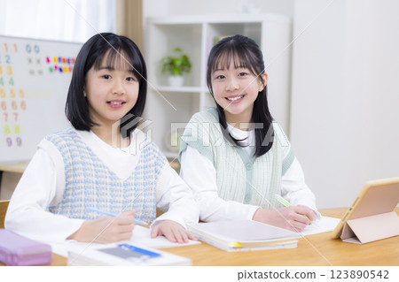Sisters doing homework in the living room 123890542