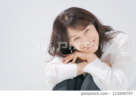 A woman in her 50s sitting with a smile 123890797