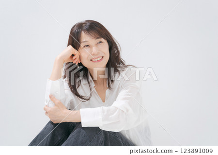 一位 50 多歲的女人微笑著坐著 123891009