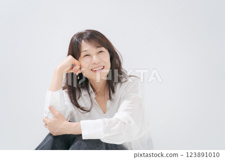 A woman in her 50s sitting with a smile 123891010
