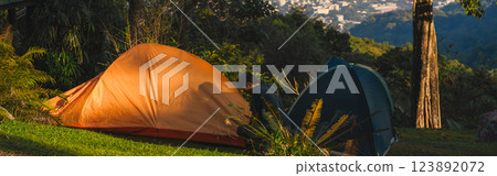 landscape and travel concept with man relax with camping tent on mountain and city background 123892072