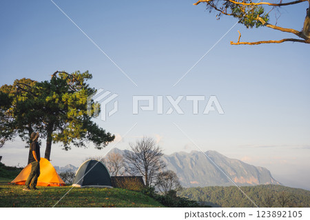landscape and travel concept with asian man relax see sunset camping tent on mountain landscape and travel concept with asian man relax see sunset camping tent on mountain 123892105