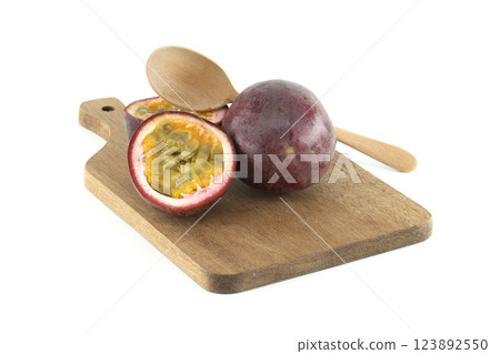 Fresh passion fruits and wooden spoon resting on cutting board 123892550
