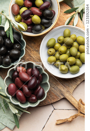 Green, black and kalamata olives displayed on wooden board 123892864