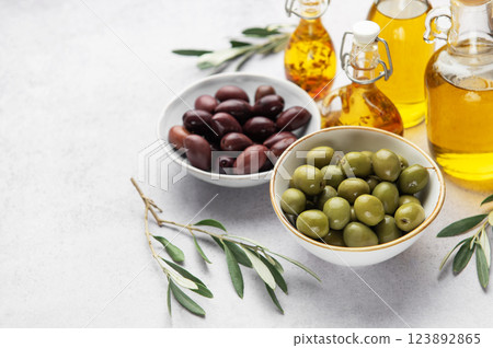 Bowls of green and black olives with olive oil bottles and olive branches Bowls of green and black olives with olive oil bottles and olive branches 123892865