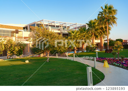Luxurious resort landscape with palm trees and lush garden during golden hour in a serene tropical location 123893193