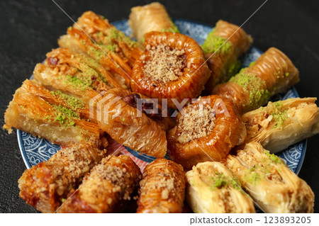 Assorted traditional pastries on a blue decorative plate in a cozy setting during afternoon tea 123893205