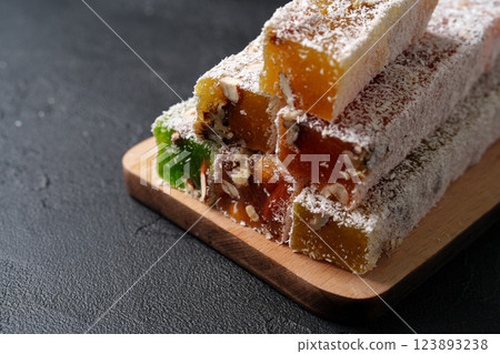Turkish delight stacked on a wooden board, showcasing vibrant colors and textures in a close-up display 123893238