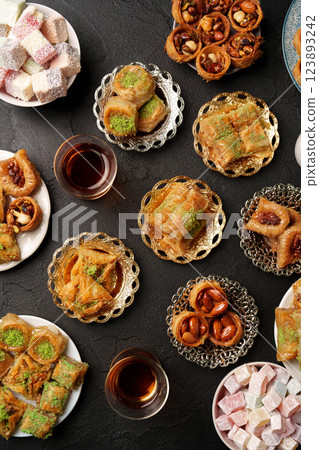 Delightful assortment of Middle Eastern sweets served with tea on elegant plates Delightful assortment of Middle Eastern sweets served with tea on elegant plates 123893242
