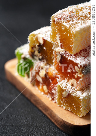 Colorful Turkish delight stacked on a wooden board with coconut flakes on top 123893253