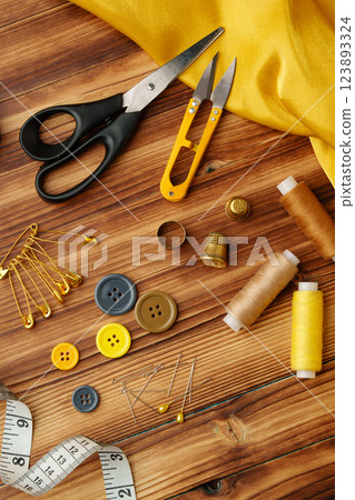 Crafting tools and materials arranged on a wooden table ready for sewing and creative projects Crafting tools and materials arranged on a wooden table ready for sewing and creative projects 123893324