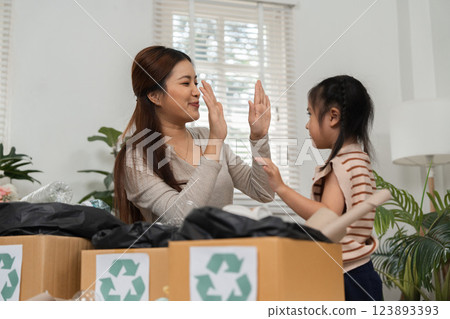 Recycling Fun and Mindfulness. A mother communicates and connects with her daughter while sorting recyclables. Recycling Fun and Mindfulness. A mother communicates and connects with her daughter while sorting recyclables. 123893393