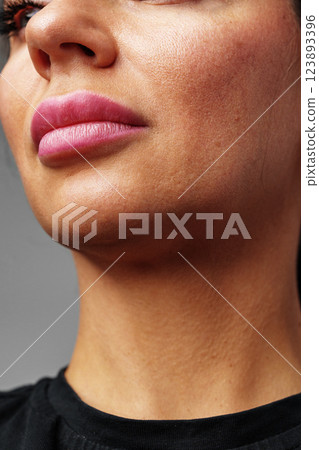 woman showcasing her natural skin texture and subtle lip color in soft lighting woman showcasing her natural skin texture and subtle lip color in soft lighting 123893396