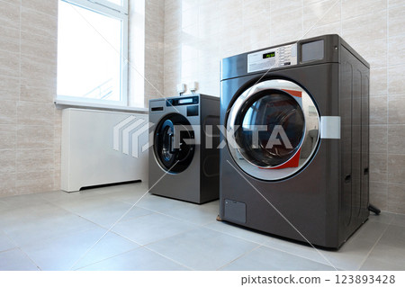 Modern laundry room featuring stylish washing machine and dryer in a bright space with ample natural light 123893428