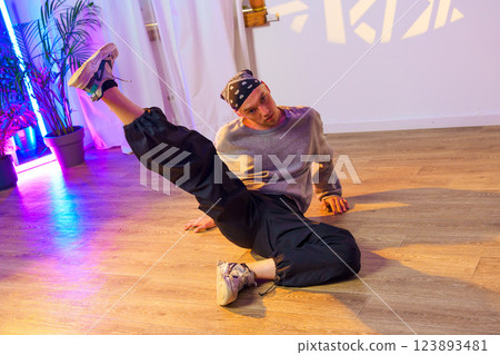 A dancer practices a move on the floor of a dance studio A dancer practices a move on the floor of a dance studio 123893481