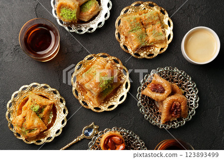 Baklava and tea served on ornate plates at a traditional dessert gathering in the afternoon 123893499