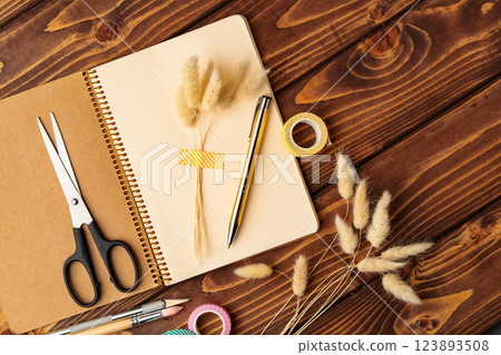 Creative workspace with stationery and natural elements on a wooden table Creative workspace with stationery and natural elements on a wooden table 123893508