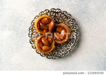 Delicious traditional pastry with almonds served on an ornate plate showcasing intricate design 123893549