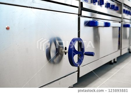Kitchen equipment features metallic surface and distinct blue knobs while preparing for cooking activities Kitchen equipment features metallic surface and distinct blue knobs while preparing for cooking activities 123893881