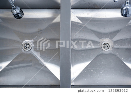 Cleaning stainless steel sinks in a commercial kitchen after meal preparation 123893912