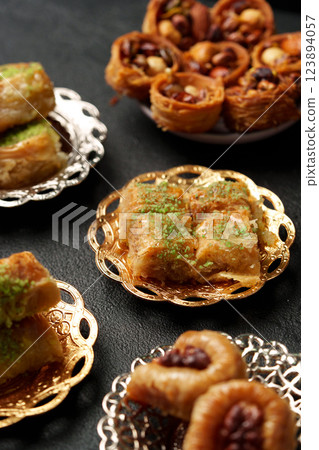 Delicious assortment of traditional Middle Eastern sweets served on decorative plates at a festive gathering Delicious assortment of traditional Middle Eastern sweets served on decorative plates at a festive gathering 123894057